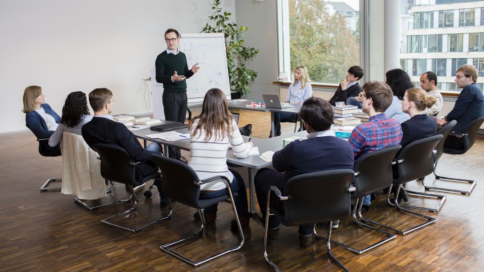 A group of lawyers discusses legal problems in a seminar room of the Max Planck Institute for International Private Law in Hamburg.